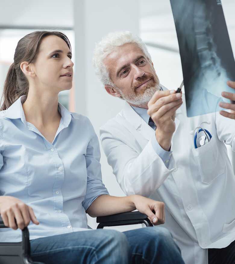 Spinal Cord Injury Lawyers in Houston, TX - Doctor showing x-ray to woman in wheelchair