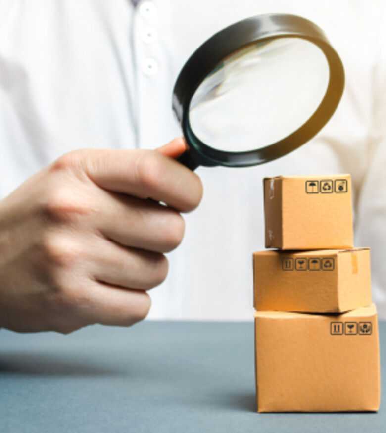 Person examining small packages with magnifying glass