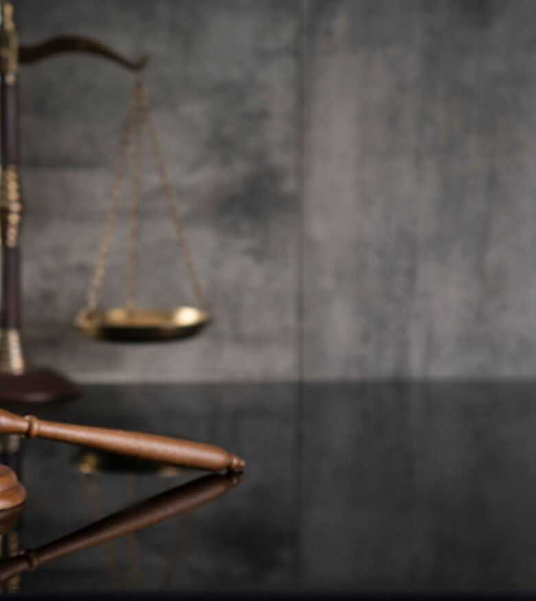 Scales of justice and gavel on dark background