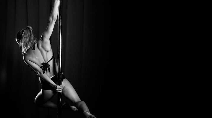 Scarlett's Cabaret Strip Clubs Will Settle Dancers' Wage Suit for $6M - A woman performing a dance on a pole.