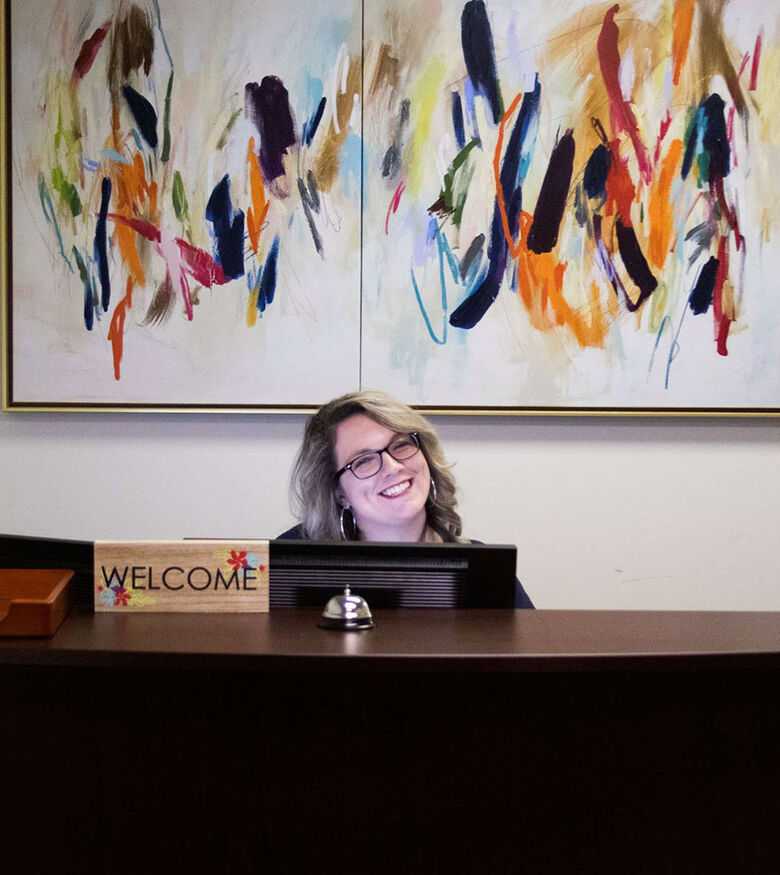 Professional personal injury lawyer working at a desk in Mobile, with colorful artwork in the background.