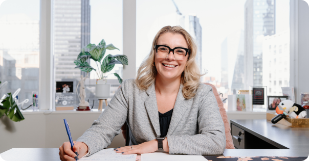 Woman at a desk signing a piece of paper