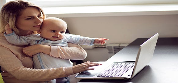 Mother with baby in front of laptop