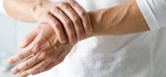 elderly person holding wrist