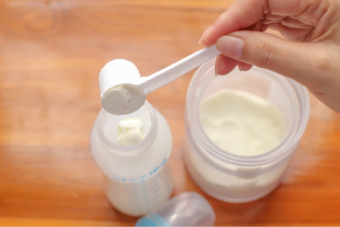 putting baby formula into a baby bottle