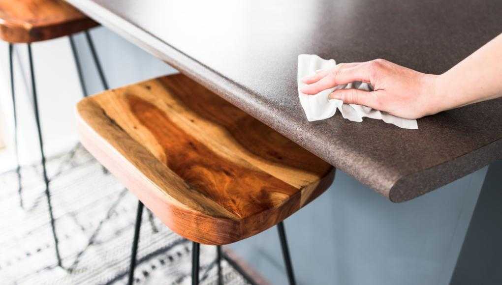 Person cleaning the table with a wipe