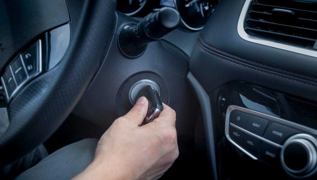 Someone turning a key to start a car