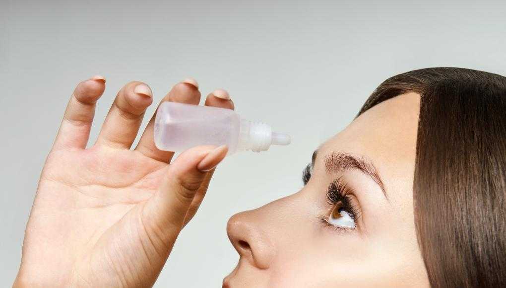 Woman putting in eye drops