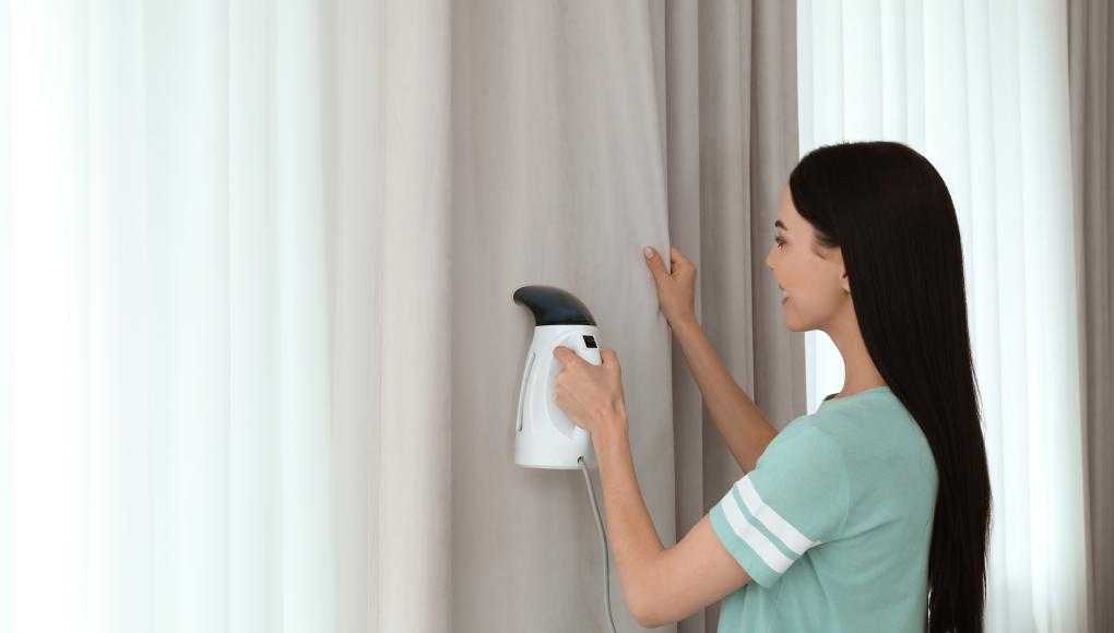 Woman steaming a curtain 