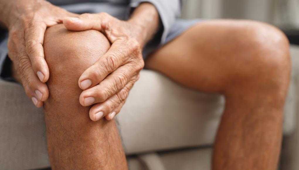 Man holding knee in pain 