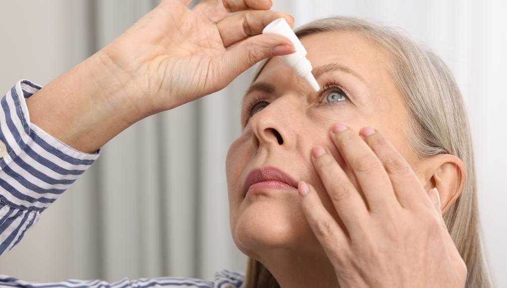 Woman putting in eye drops