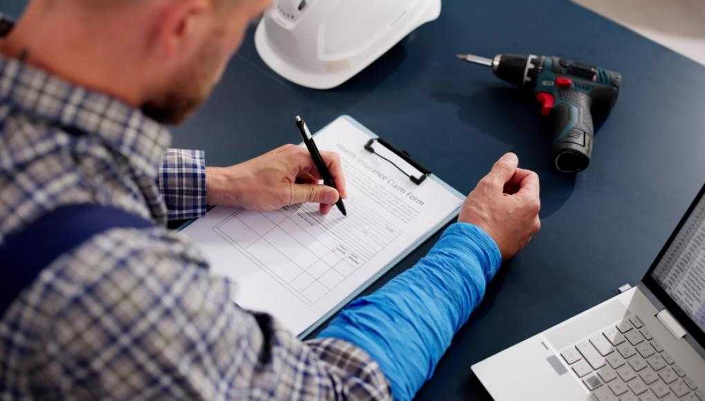 man signing workers' compensation forms
