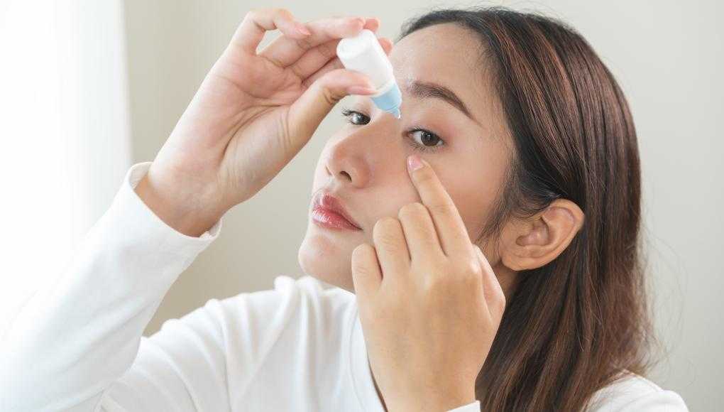 Woman putting in eye drops