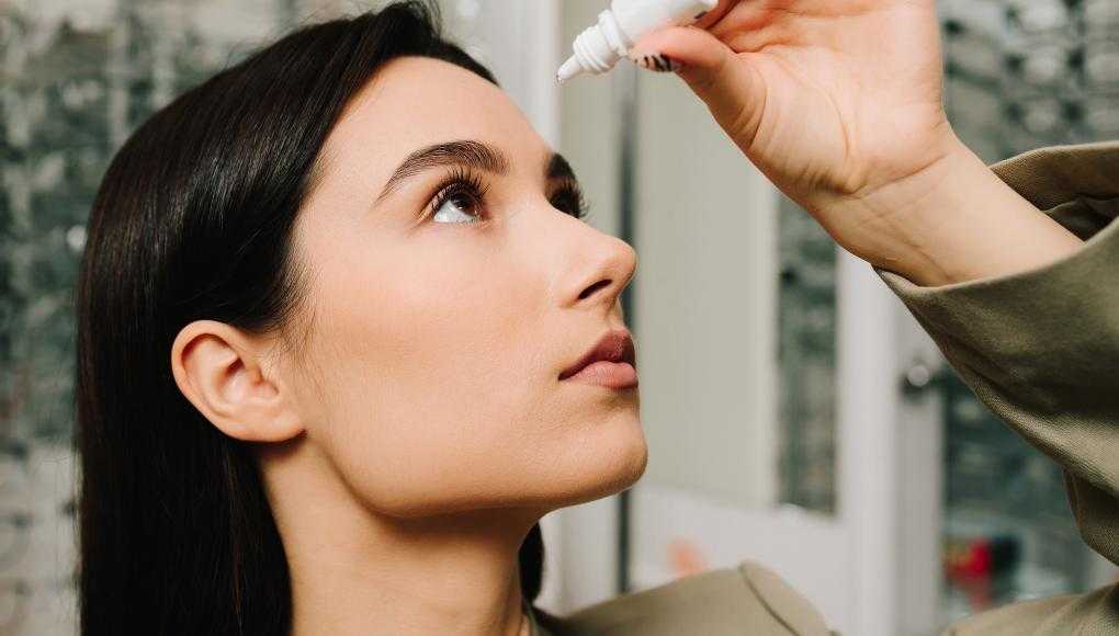 Woman putting in eye drops