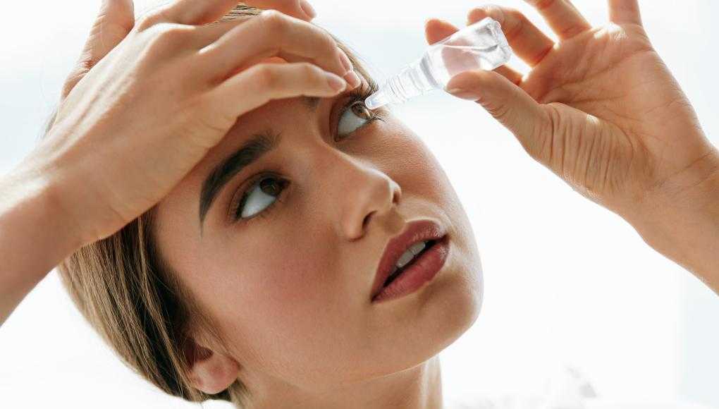 Woman putting in eye drops