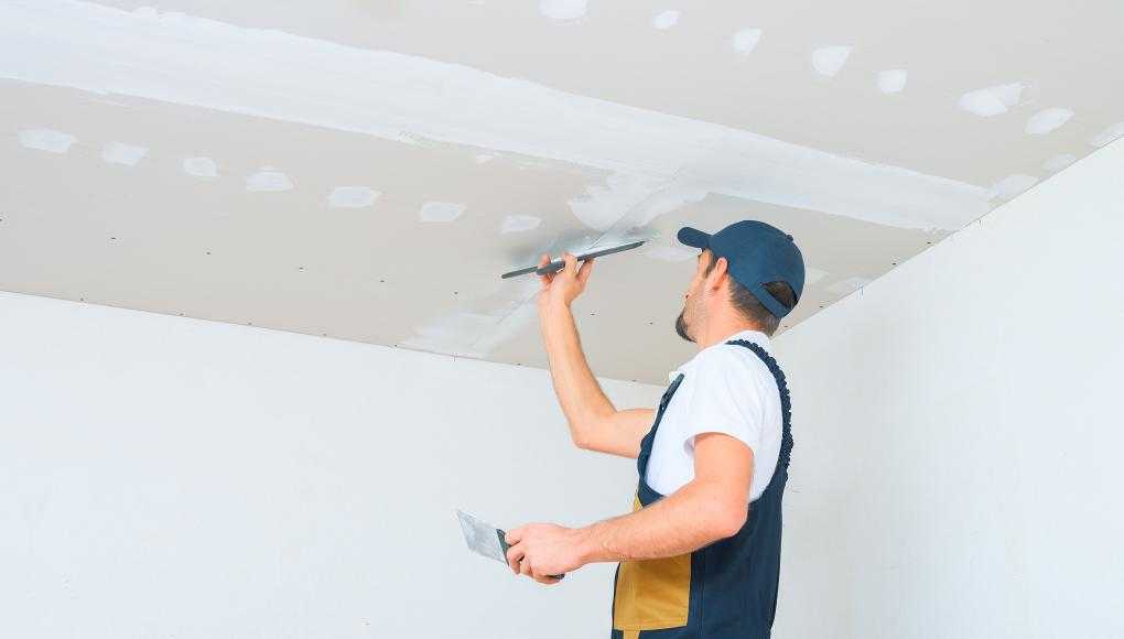 Man putting up drywall