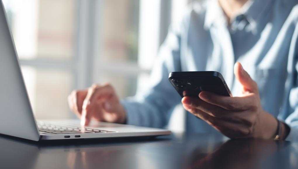 Person using laptop and phone