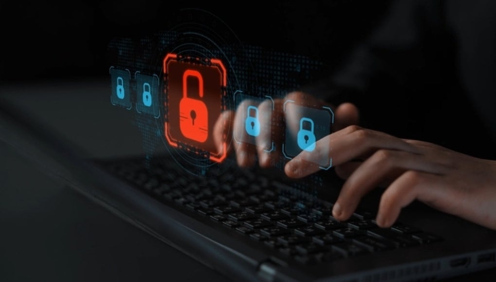 person typing on keyboard with a error message on security lock indicating data breach 