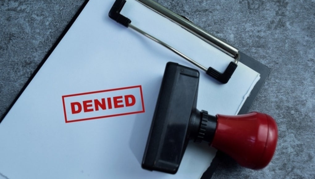 clipboard with stamp that reads denied 