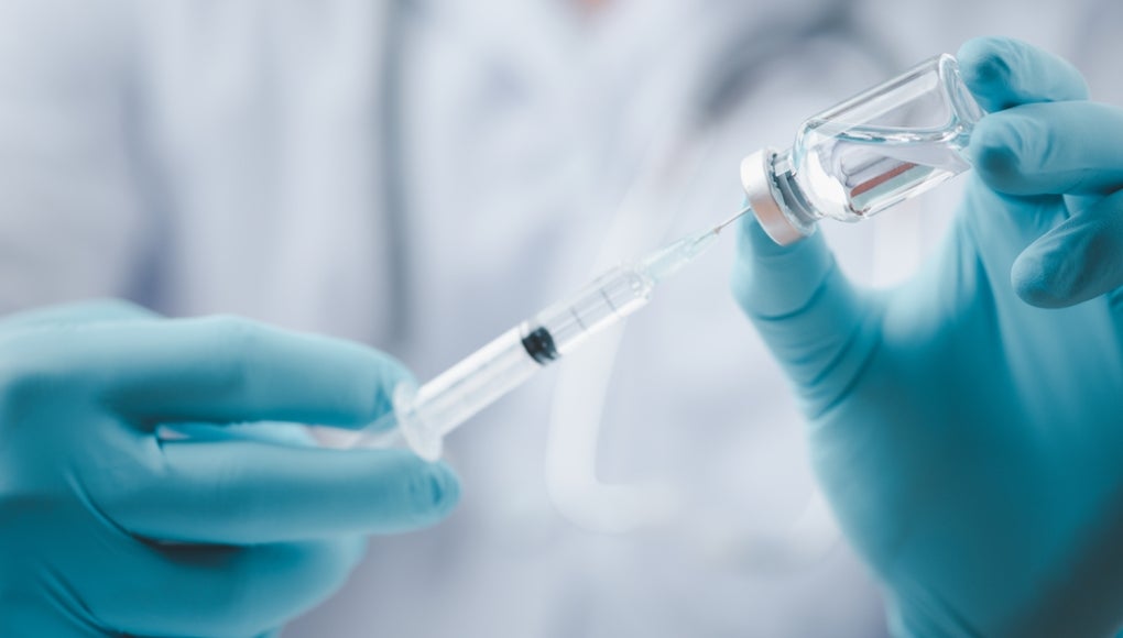 Medical professional using a syringe
