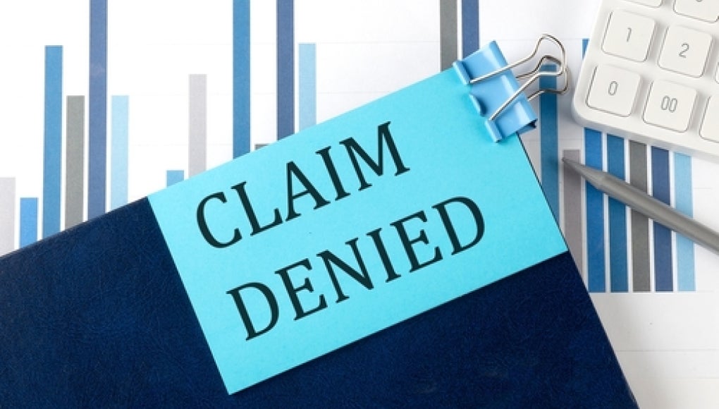 claim denied on a blue sticky note on a clipboard 