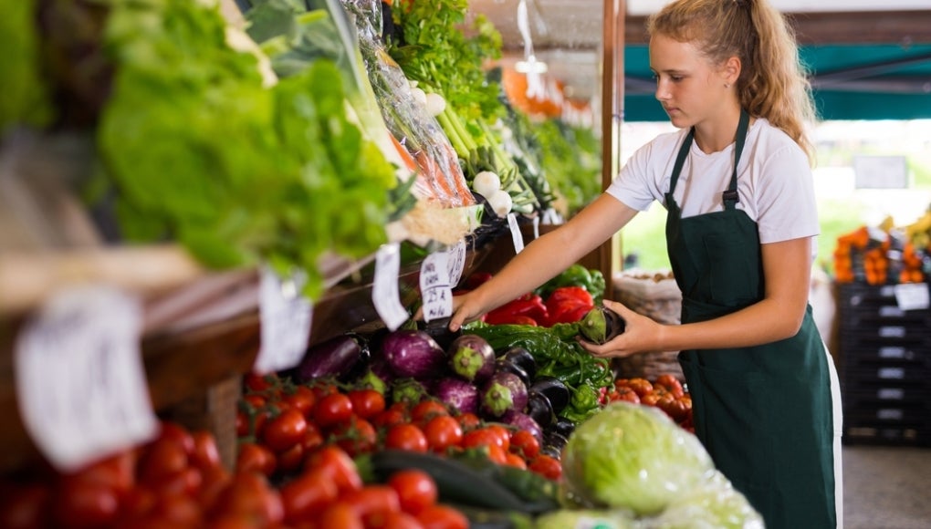 teenager stocking fruit