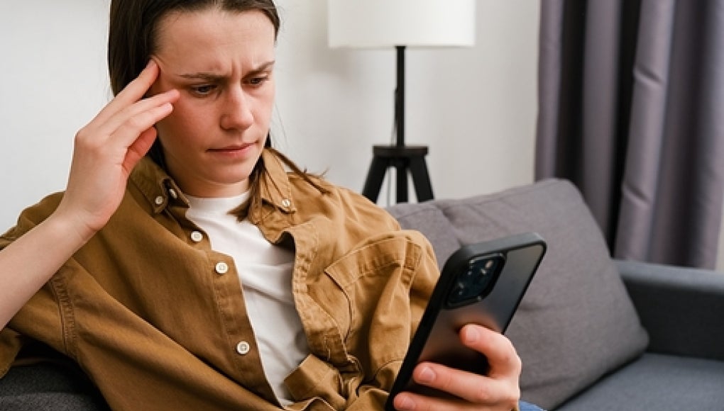 person upset looking at phone reading messages 