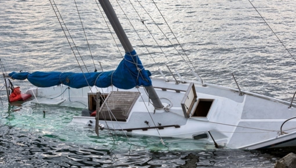 white boat capsizing in water