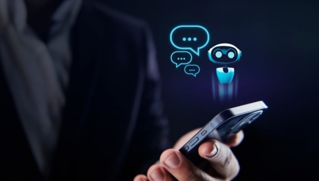 person holding phone with a ai chat bot illustrated floating above it 