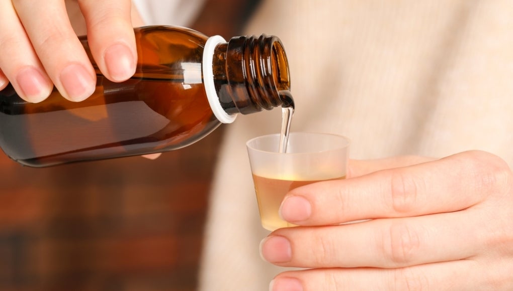 Woman pouring medication into cup