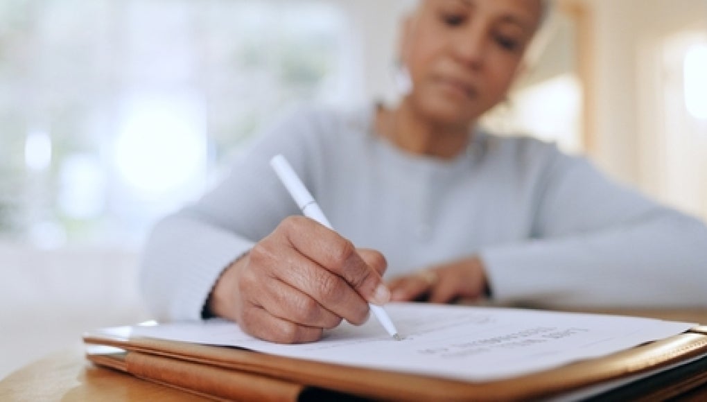 woman sitting with documents and forms for life insurance 