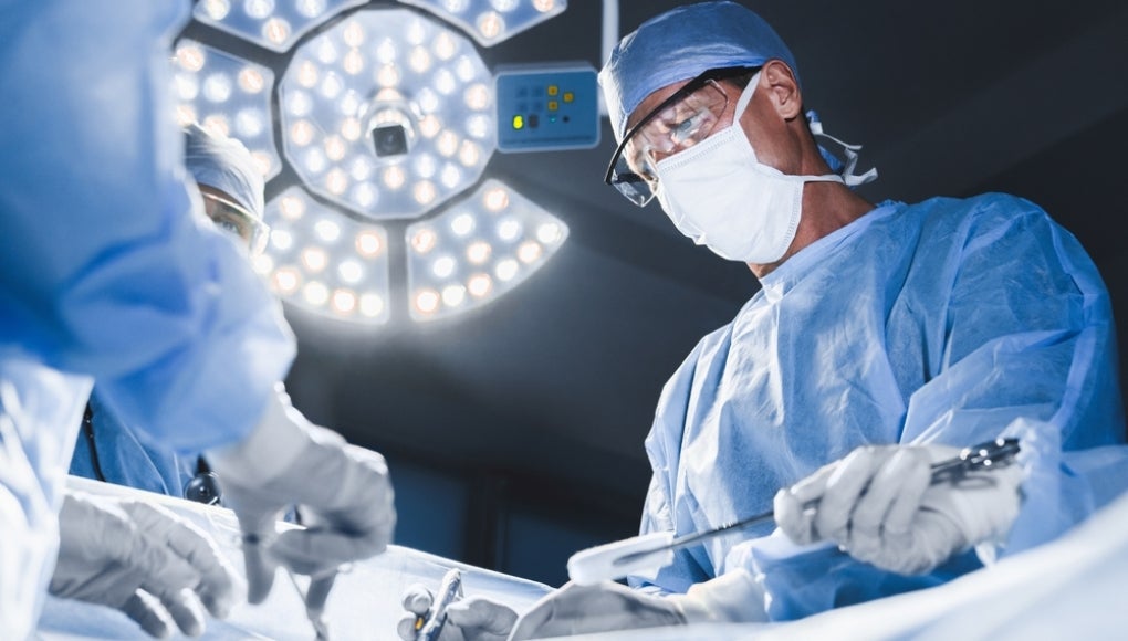 Group of surgeons at operation in operating room at hospital. Surgery, medicine and people concept. Medical case, urgent treatment, microsurgery concept