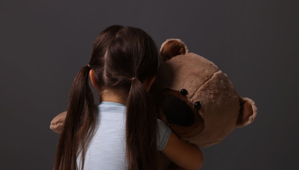 sad child holding teddy bear