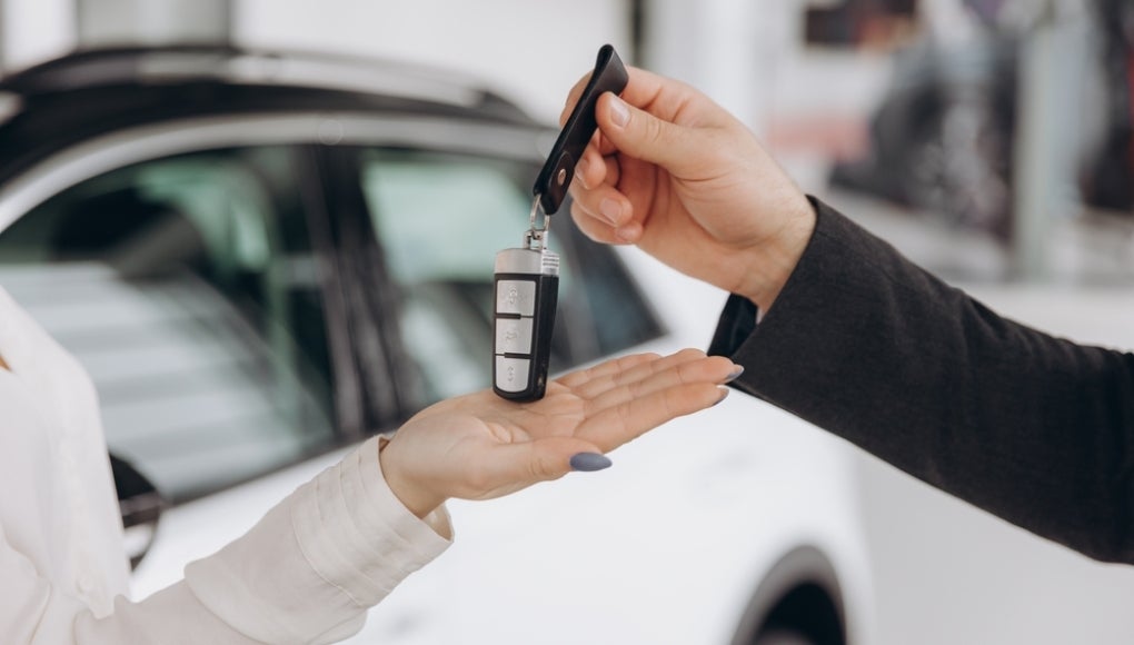 Action of human hands are giving and taking a car key. Buying the new car or car rental business concept scene, Close-up and selective focus at the object.