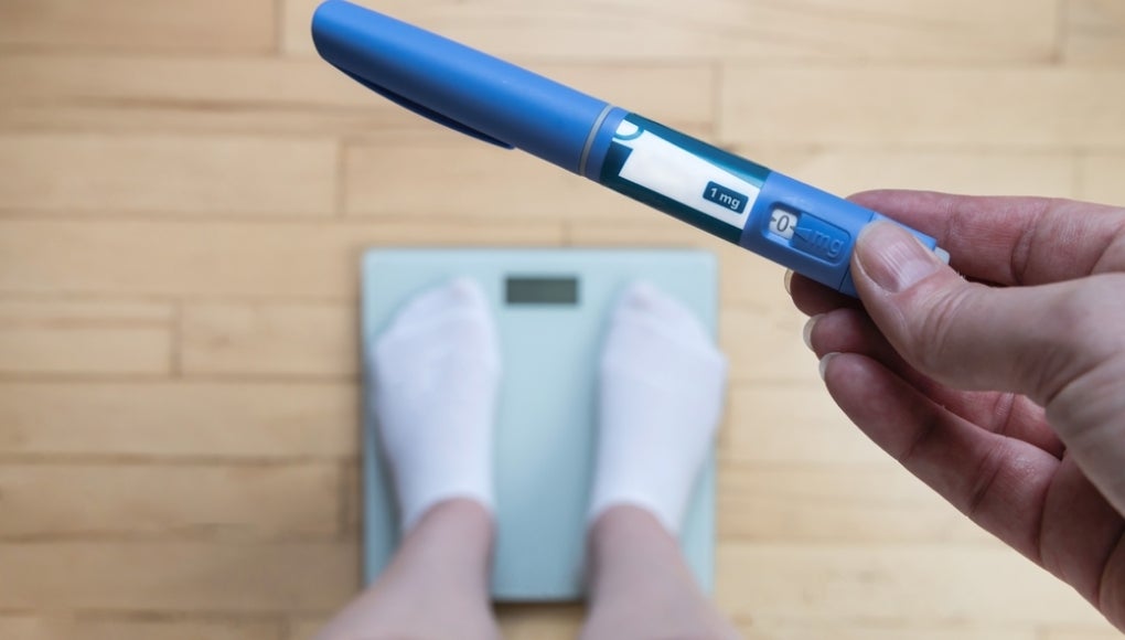 standing on a scale with a weight loss drug