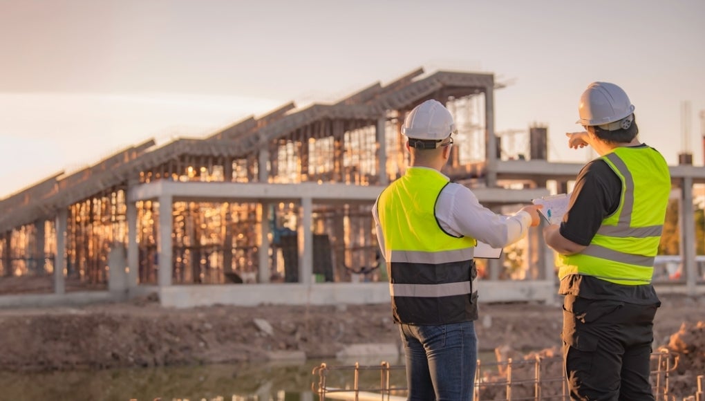 Construction worker helping another worker