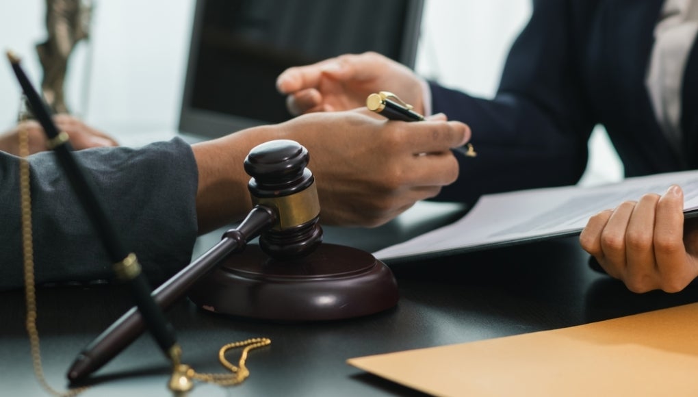 client with their lawyer in a courtroom