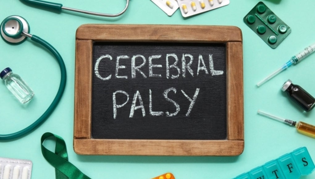 medical supplies, green ribbon, and chalkboard with cerebral palsy written on it. 