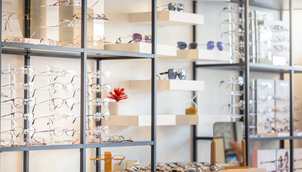 Corrective eye glasses on shelf in optical store, Row of spectacles on shelves in eyeglasses shop