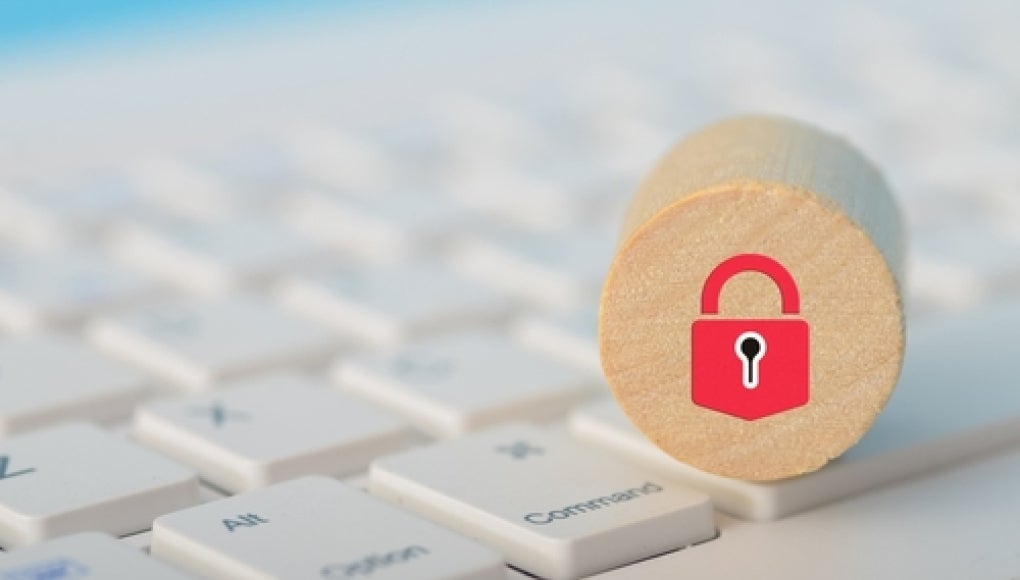 keyboard with a wooden circle resting on top of it with a red lock illustrated on the block