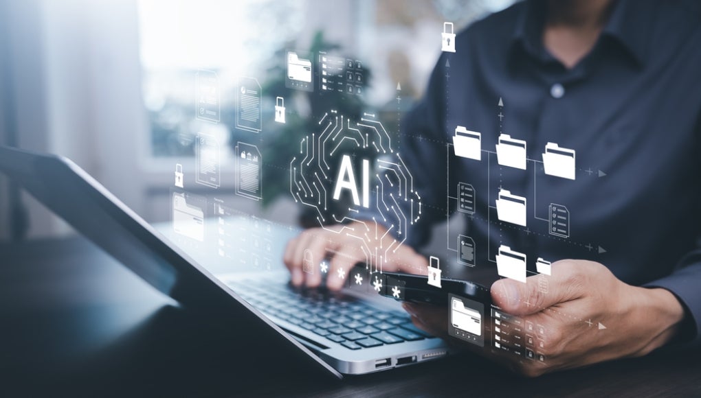 Person using laptop and smartphone with virtual AI interface, data folders, and digital security icons. Concept of artificial intelligence, data management, and cloud computing technology.