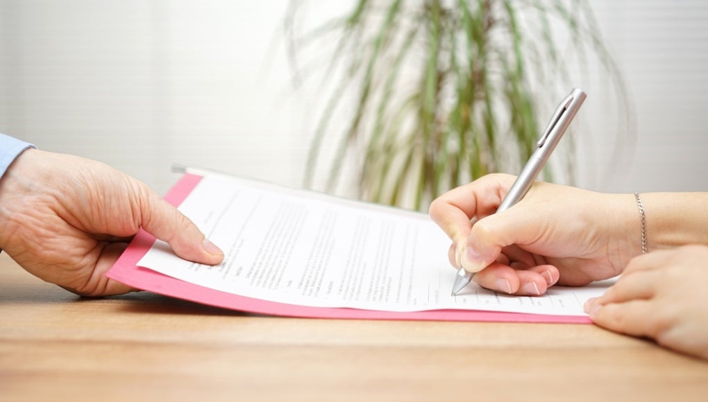 boss gives employee dismissal contract to sign