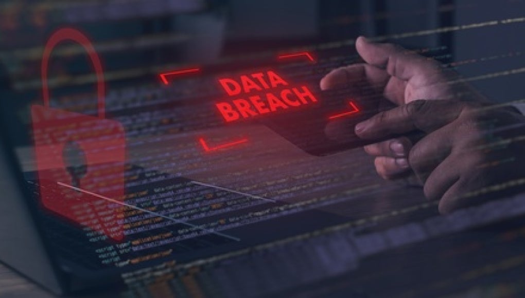 data breach image of a red warning sign that appears above a keyboard 