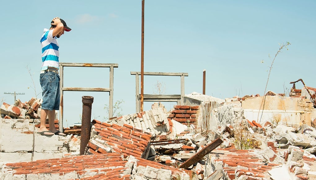 Man looking at collapse house