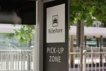 sign for rideshare pick up zone showing a rideshare car
