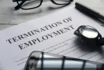 employment termination letter with phone, watch and pen overlaid on top of it