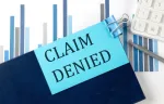 claim denied on a blue sticky note on a clipboard 