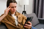 person upset looking at phone reading messages 