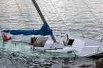 white boat capsizing in water