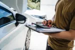 person filling out forms for car